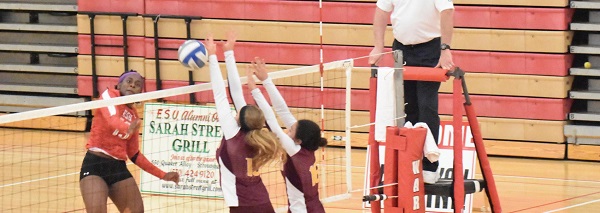 Senior outside hitter #13 Desiree Claxton (left in red) goes for the kill. Photo Credit / Ronald Hanaki