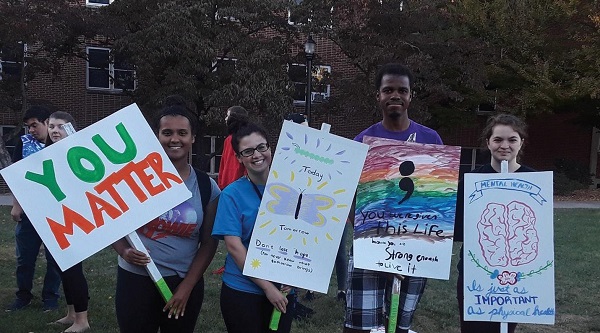 Photo Credit / Ashley Levin From left, Sophia Cabrera, Alyssa Mesi, David James, and Zoe Maas hold up signs advocating the importance of mental health.