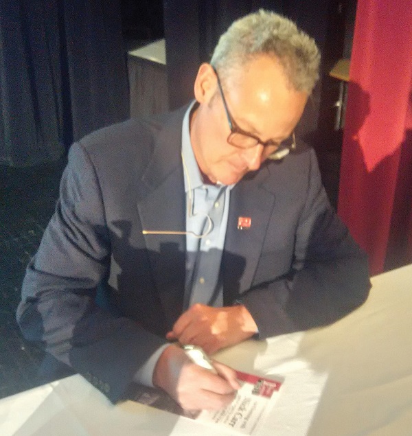 Carr signing programs at the end of the discussion. Photo Credit / Edita Bardhi