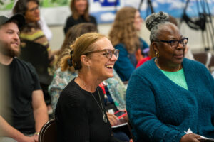 Photo faculty and staff smiling and listening the presentation.