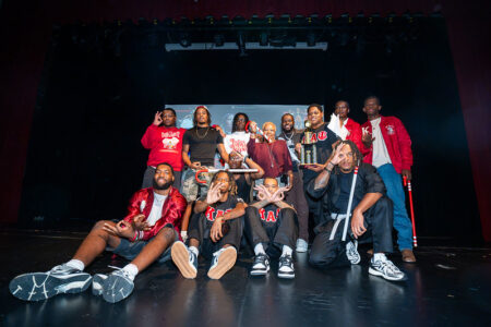 A group of people on a stage holding up a trophy.