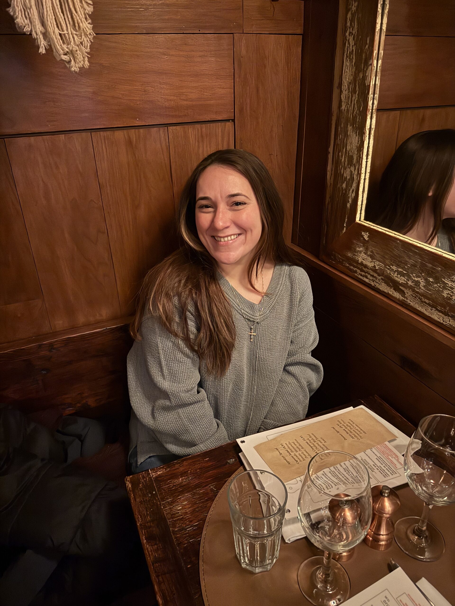 A smiling woman sitting at a wooden table