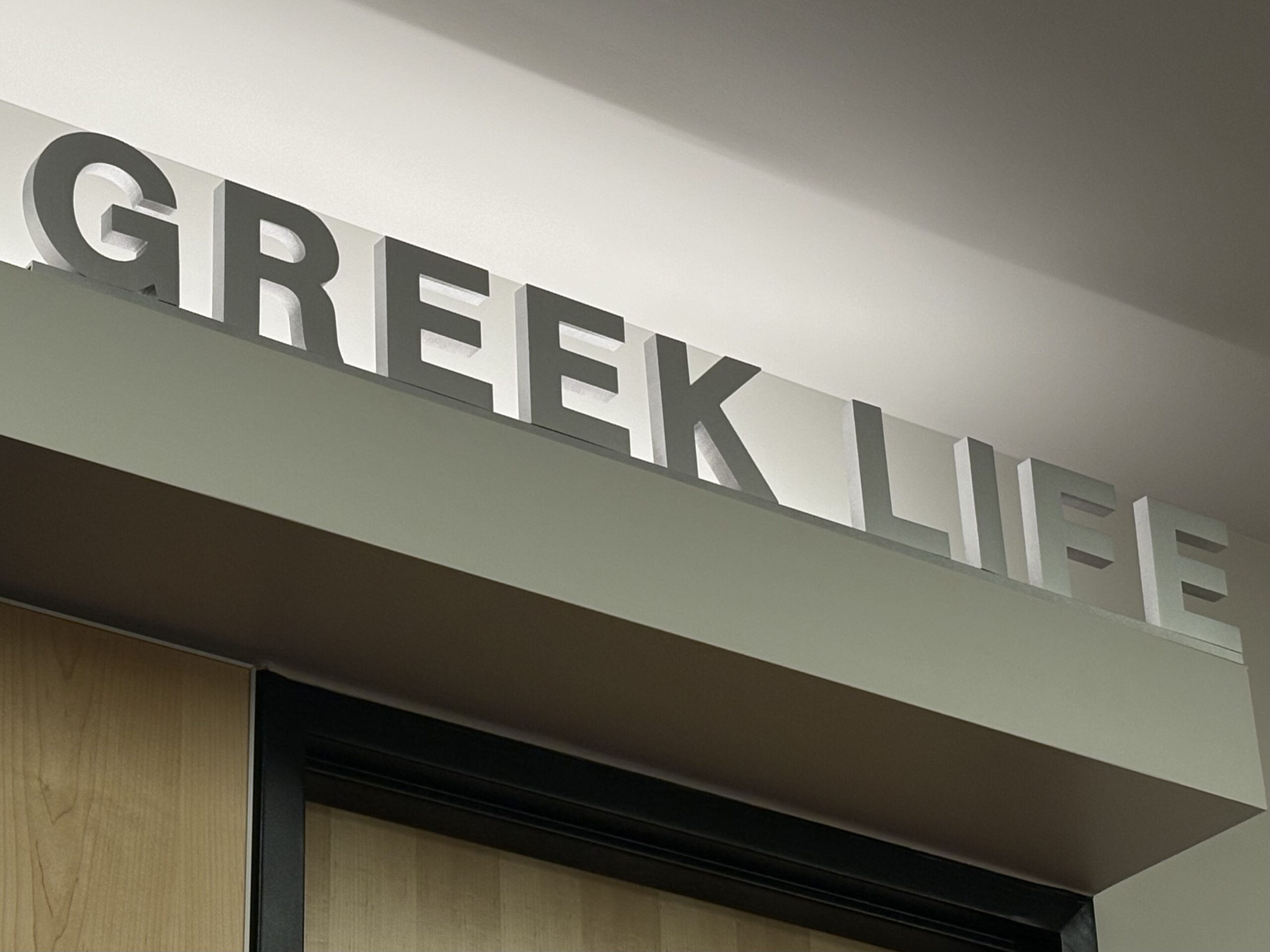 A sign made up of large grey letters that spell "Greek Life"